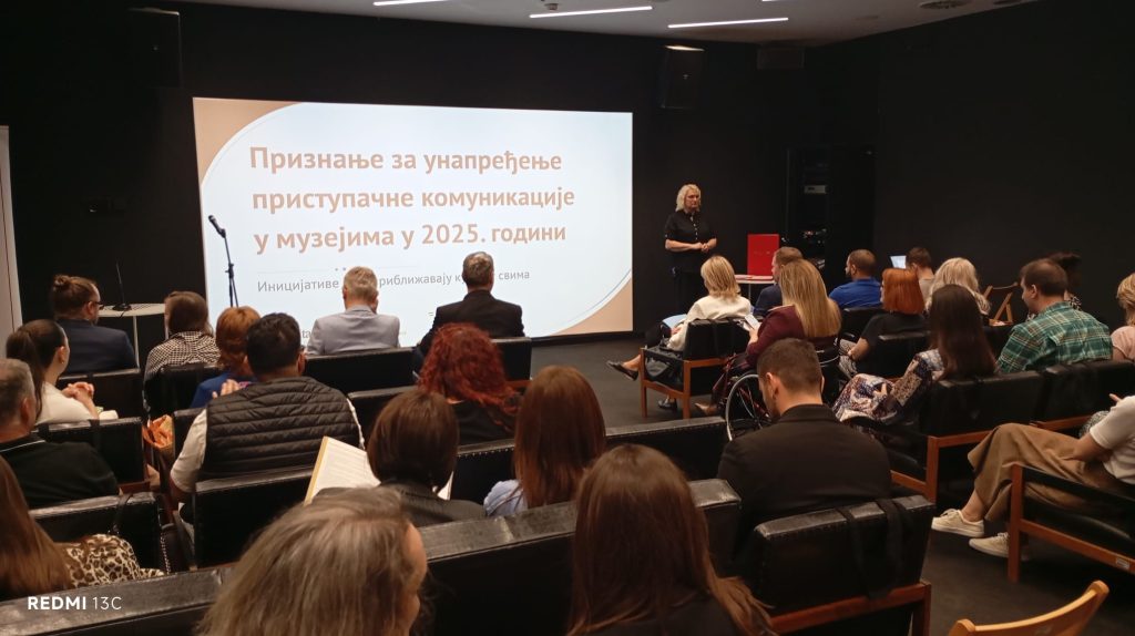 Учесници седе у сали и види се презентација са називом догађаја